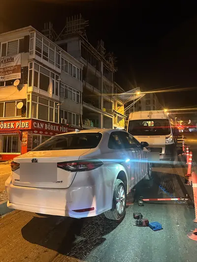 Gece cadde kenarında sedan aracın arka lastiğinin değişimi