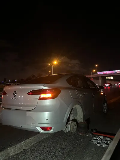 Gece otoyol kenarında sedan aracın sökülmüş arka tekeri