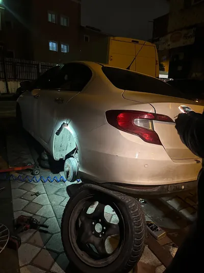 Gece sokakta sedan aracın arka tekerinin sökülüp lastiğinin değiştirilmesi